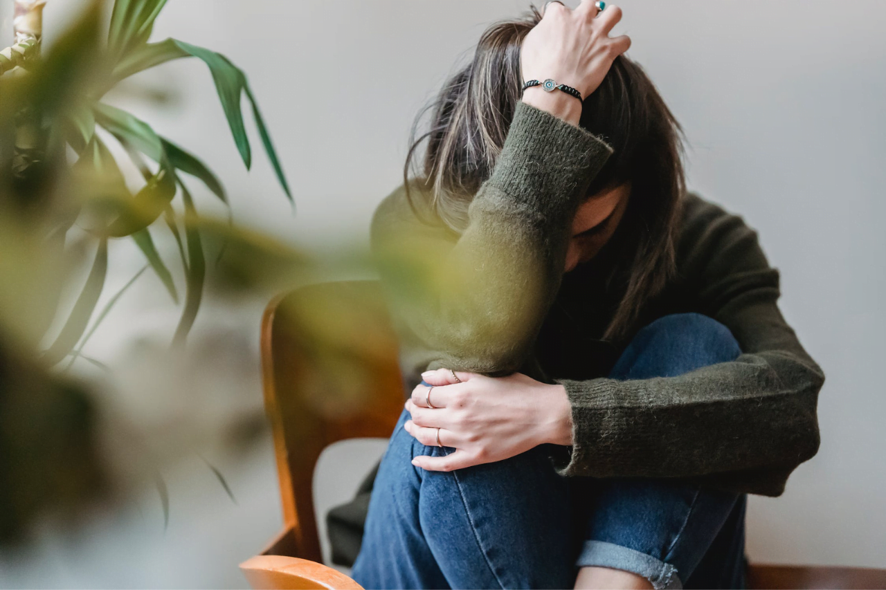 kvinna på stol som drar sig i håret av stress
