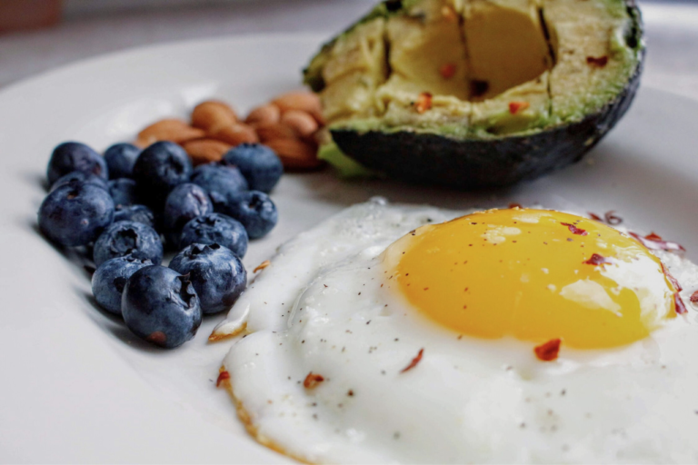 En måltid av keto med ägg, avokado, bär och nötter
