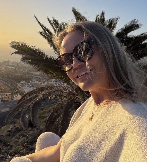 kvinna i solnedgång med palmer